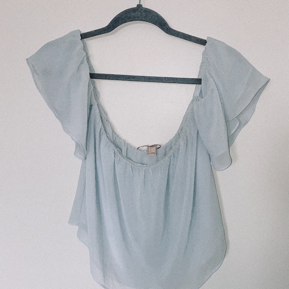Light-blue, off the shoulder shirt.